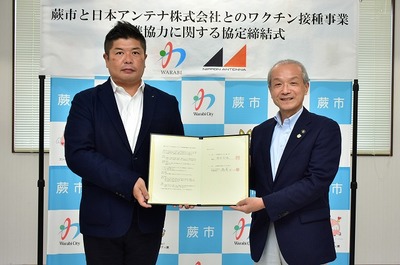 写真：協定書を持つ蕨市長と日本アンテナ関係者