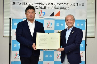 写真:協定書を持つ蕨市長と日本アンテナ関係者
