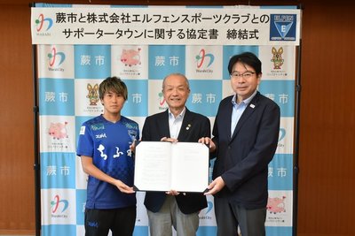写真:協定書を持つ頼高英雄市長とエルフェンスポーツクラブ社長とちふれASエルフェン埼玉の植村選手