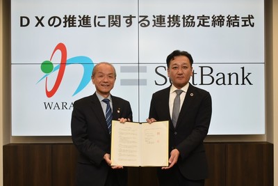 写真:協定書を持つ頼高英雄市長とソフトバンク