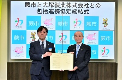 写真:協定書を持つ頼高英雄市長と田中健太郎支店長