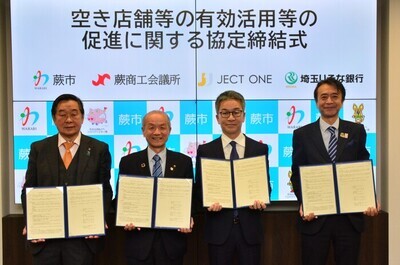 写真：協定書を持つ頼高英雄蕨市長ほか