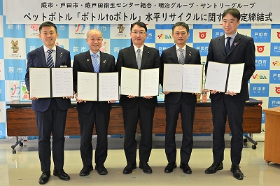 写真：協定書を持つ頼高英雄蕨市長ほか