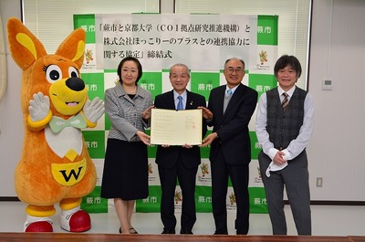 写真：協定書を持つ蕨市長と京大代表とほっこり―の代表