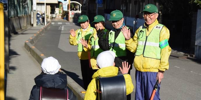 写真：下校中の児童を見守る地域のかたがた