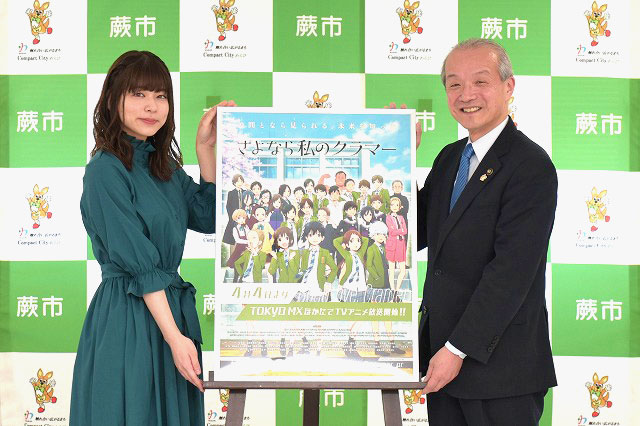 写真：島袋美由利さんと蕨市長がポスターを挟んで記念撮影