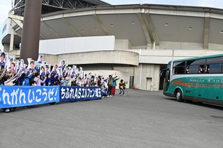 写真：ゲートフラッグで選手が乗るバスを出迎える子どもたち