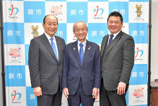 写真：片岡社長と頼高蕨市長と執行役員の坂上さん