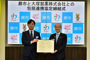 写真:協定書を持つ田中支店長と市長